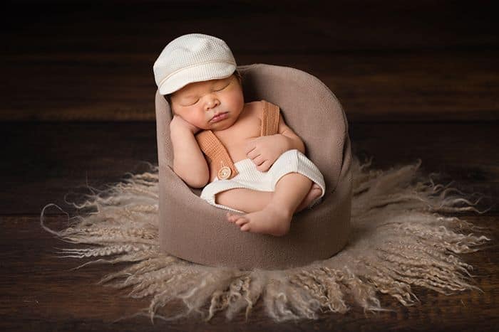 Verspielte Babyfotografie im Studio Düsseldorf – entspanntes Baby liebevoll eingekuschelt