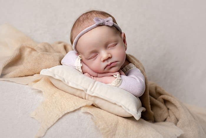 Verspielte Babyfotografie im Studio Düsseldorf – schlafendes Baby mit Stirnband in natürlicher Pose